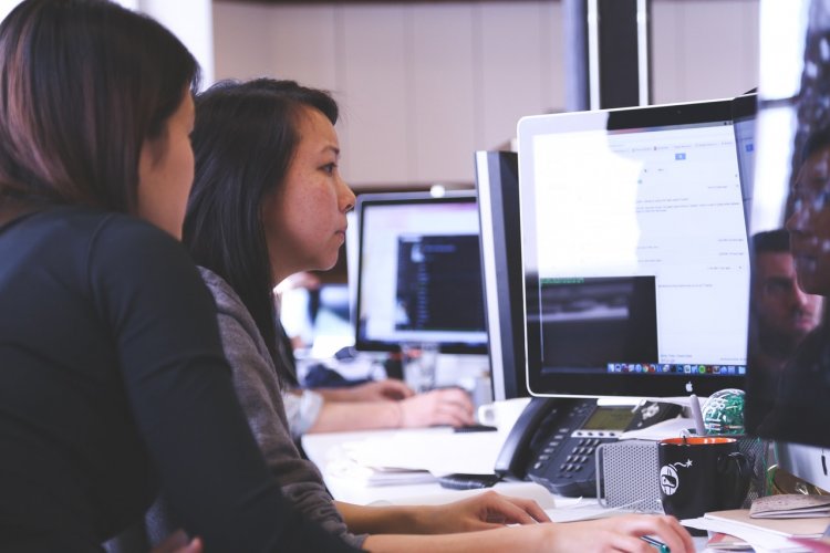 Two women using a computer together.