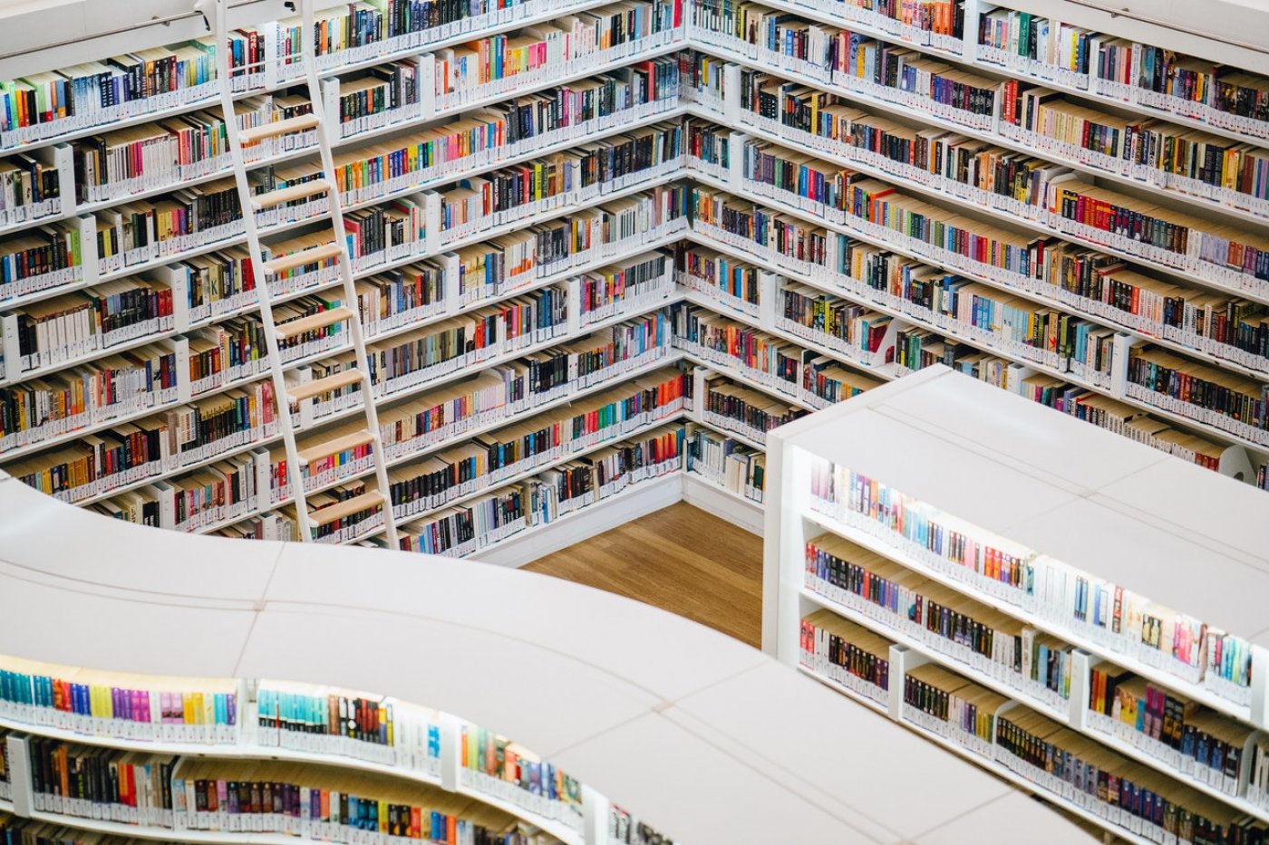 Photo of a library with large white shelves filled with books.