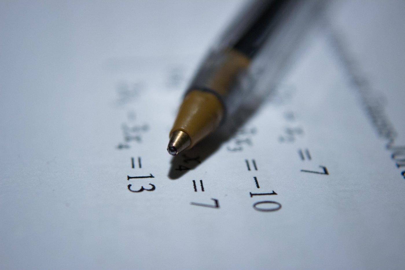 Photo of a pen on top of paper with math expressions
