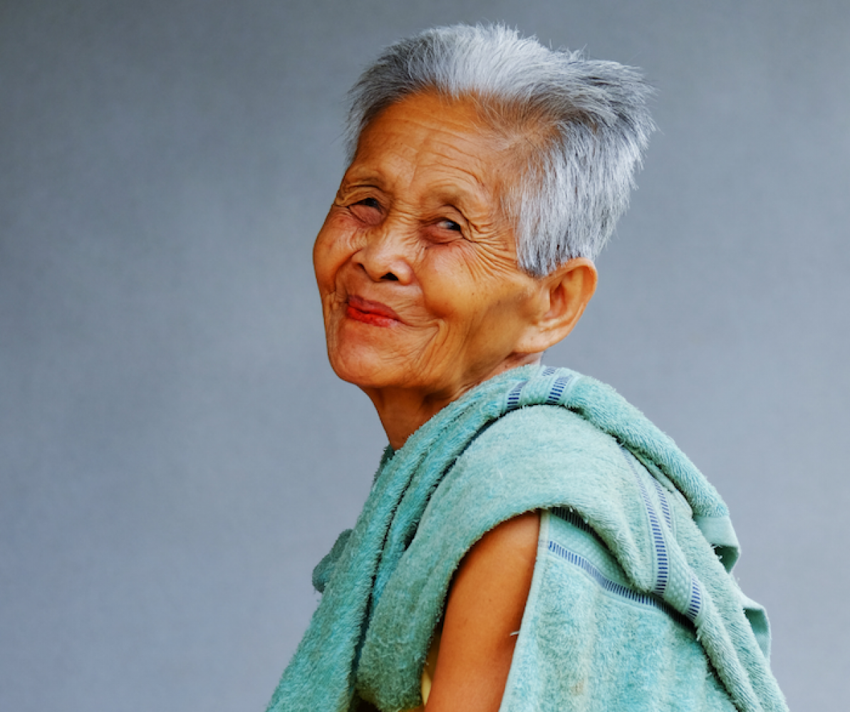 Picture of older asian woman with grey hair and green sweater